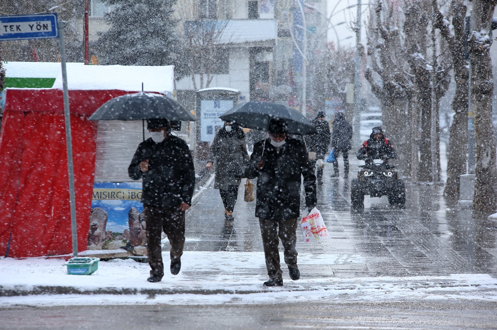 People walk amid snowfall in Çorum, central Turkey, March 20, 2022. (AA PHOTO)