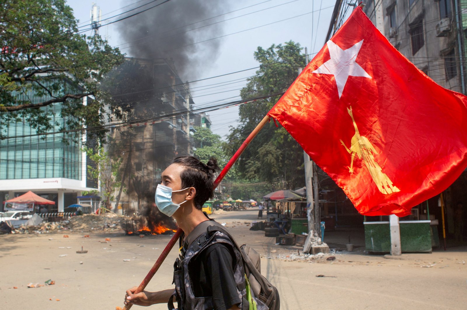 A man holds a National League for Democracy (NLD) flag during a protest against the military coup, in Yangon, Myanmar, March 27, 2021. (Reuters File Photo)