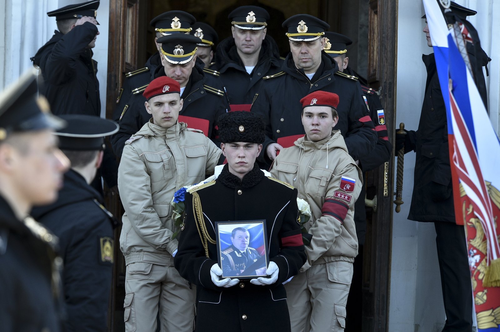 A serviceman carries the photo of Capt. Andrei Paliy, a deputy commander of Russia&#039;s Black Sea Fleet, during a farewell ceremony in Sevastopol, Crimea, March 23, 2022. (AP Photo)