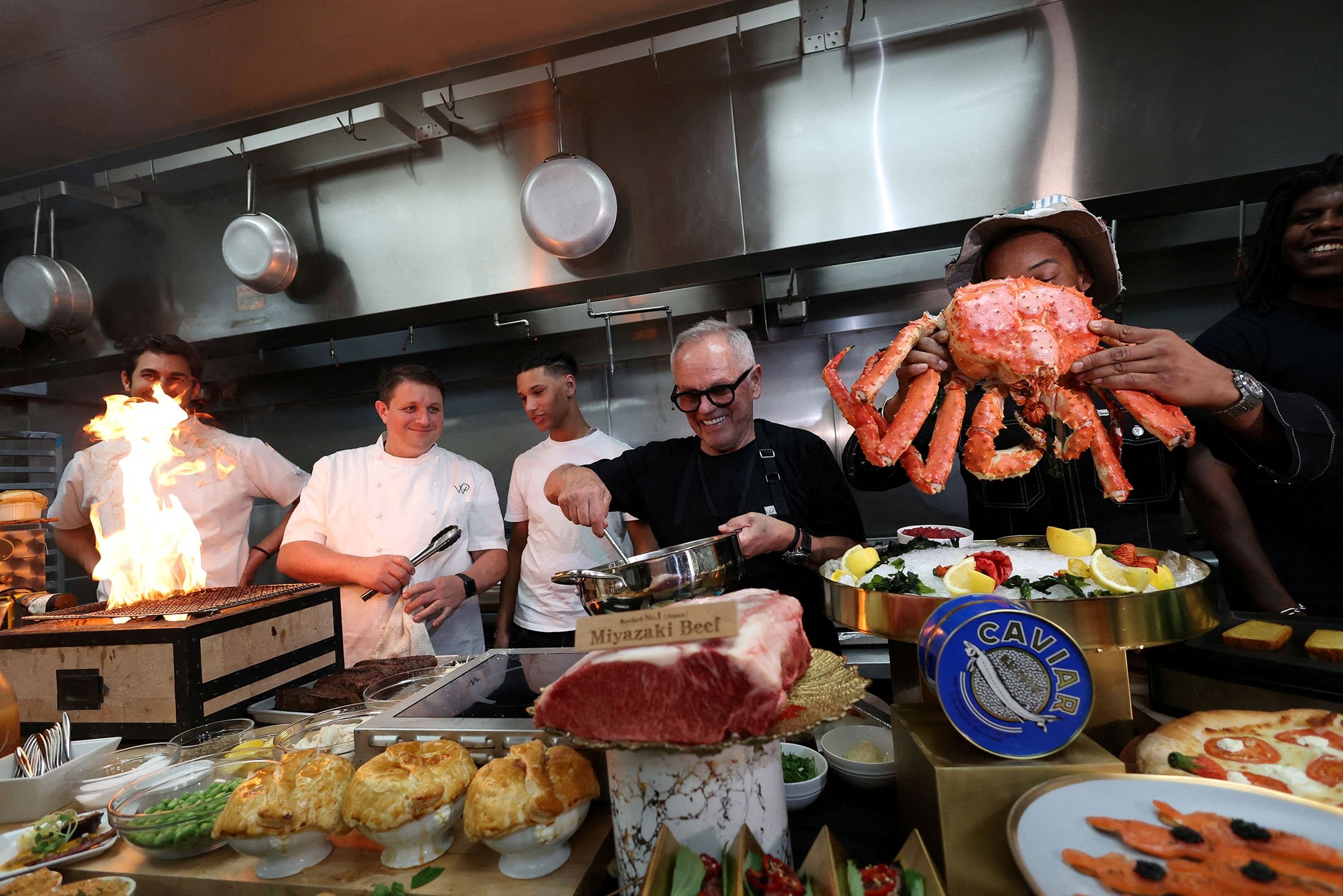 Chef Wolfgang Puck (C-R) and his team, including the chefs behind the cooking collective 