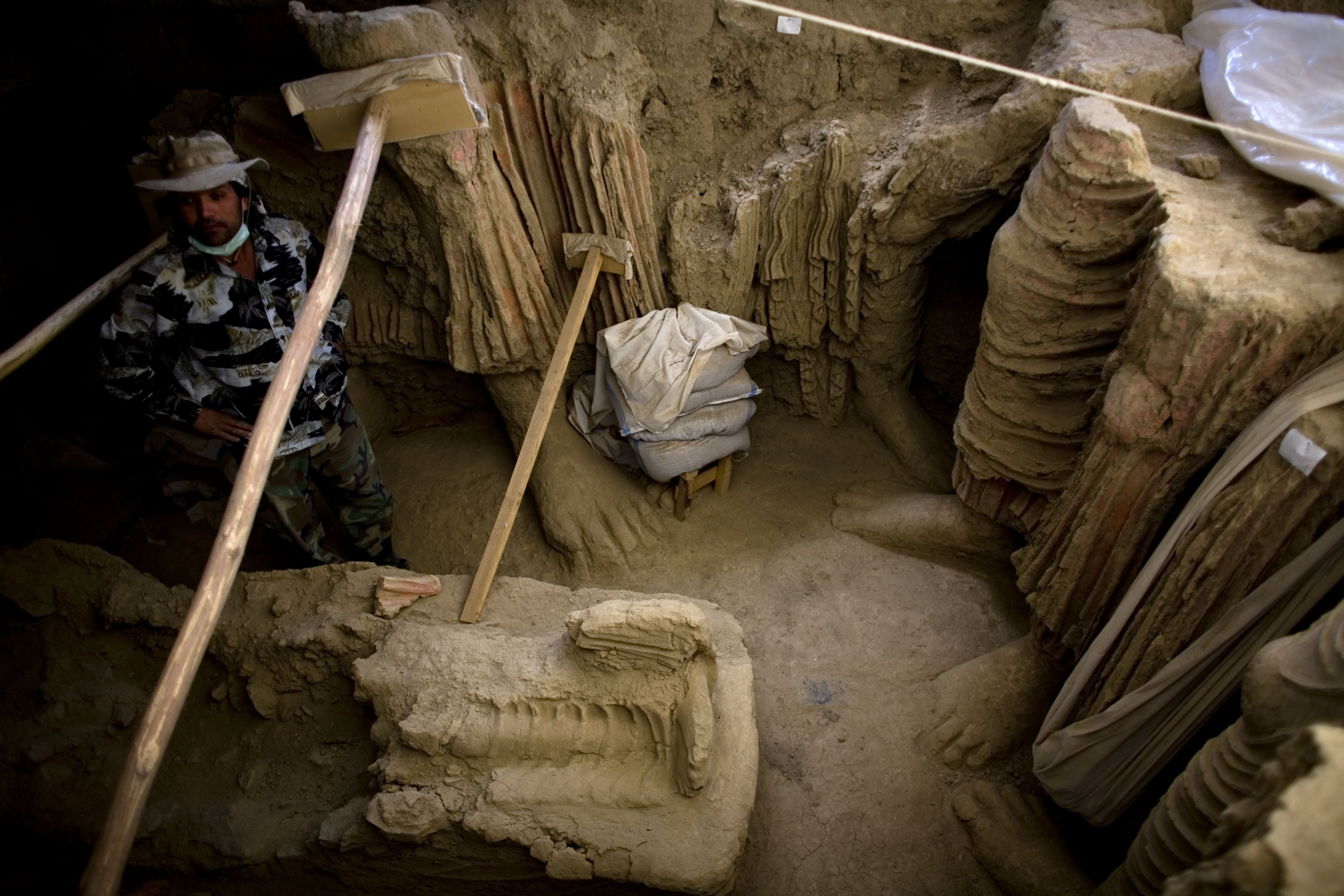 Dalam file foto ini tersedia pada 12 Oktober 2010, seorang arkeolog Afghanistan berdiri di samping sisa-sisa patung Buddha yang ditemukan di dalam sebuah kuil kuno, di lembah Mes Aynak, selatan Kabul, Afghanistan.  (Foto File AP)