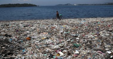 A man walks by garbage at a polluted beach on the banks of Guanabara Bay in Rio de Janeiro, Brazil, March 16, 2022. (Reuters Photo)