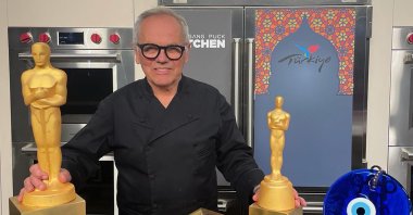 Chef Wolfgang Puck poses with Black Sea pide and Creamy Apricot Dessert prepared for the Academy Awards Governors Ball. (Photo courtesy of TGA)
