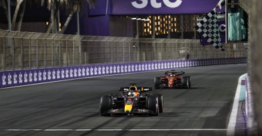 Red Bull&#039;s Dutch driver Max Verstappen (foreground) crosses the start/finish line to win the 2022 Saudi Arabia Formula One Grand Prix at the Jeddah Corniche Circuit, March 27, 2022. (AFP Photo)