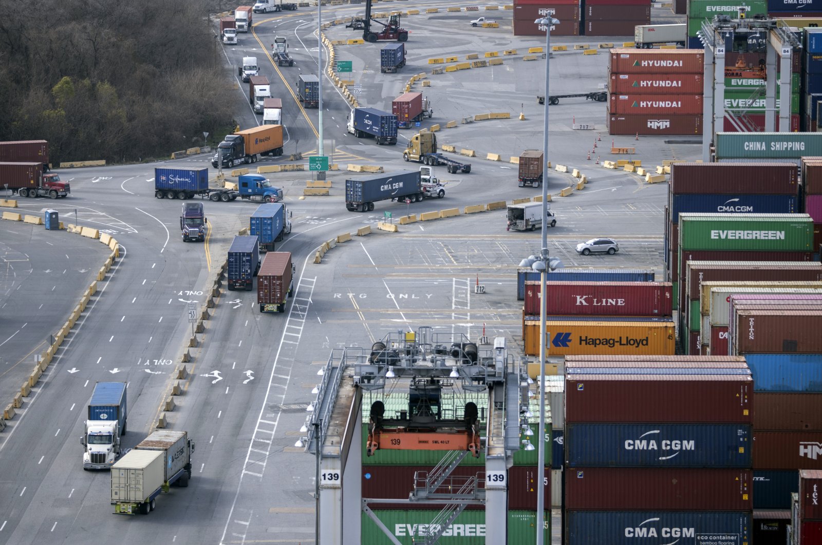 Tractor-trailers loaded with shipping containers drive through a traffic circle in the container yard at the Georgia Ports Authority&#039;s Garden City Terminal, U.S. Feb. 2, 2022. (AP Photo)