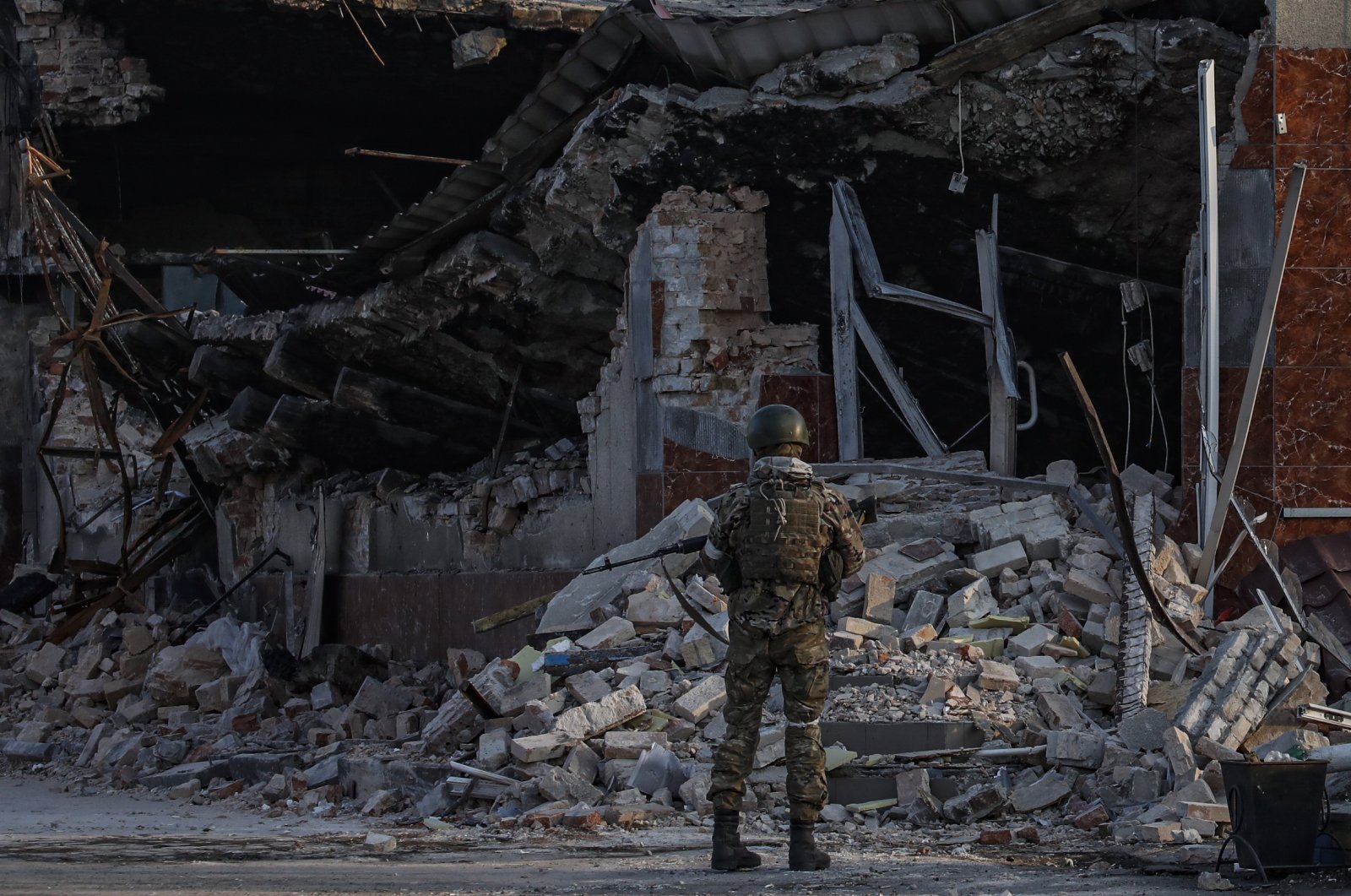 A Russian soldier examines debris of a store in downtown Volnovakha, Ukraine, March 26, 2022. (EPA Photo)