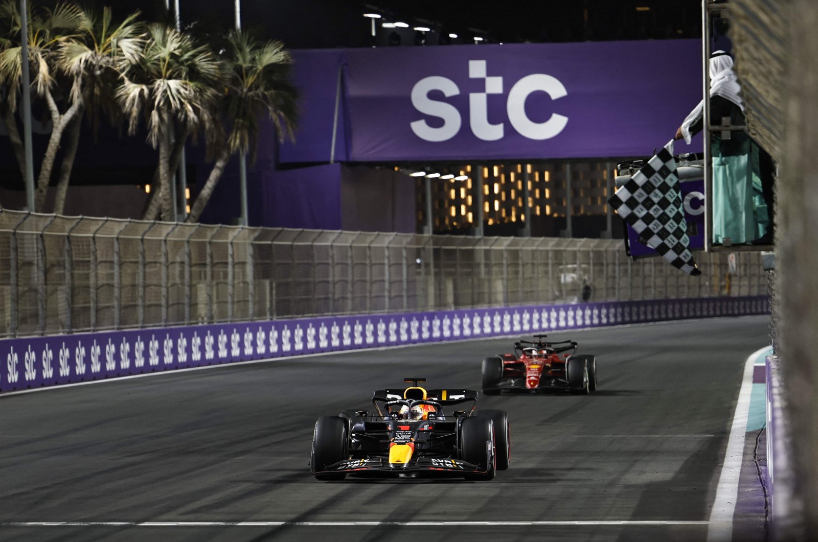 Red Bull&#039;s Dutch driver Max Verstappen (foreground) crosses the start/finish line to win the 2022 Saudi Arabia Formula One Grand Prix at the Jeddah Corniche Circuit, March 27, 2022. (AFP Photo)