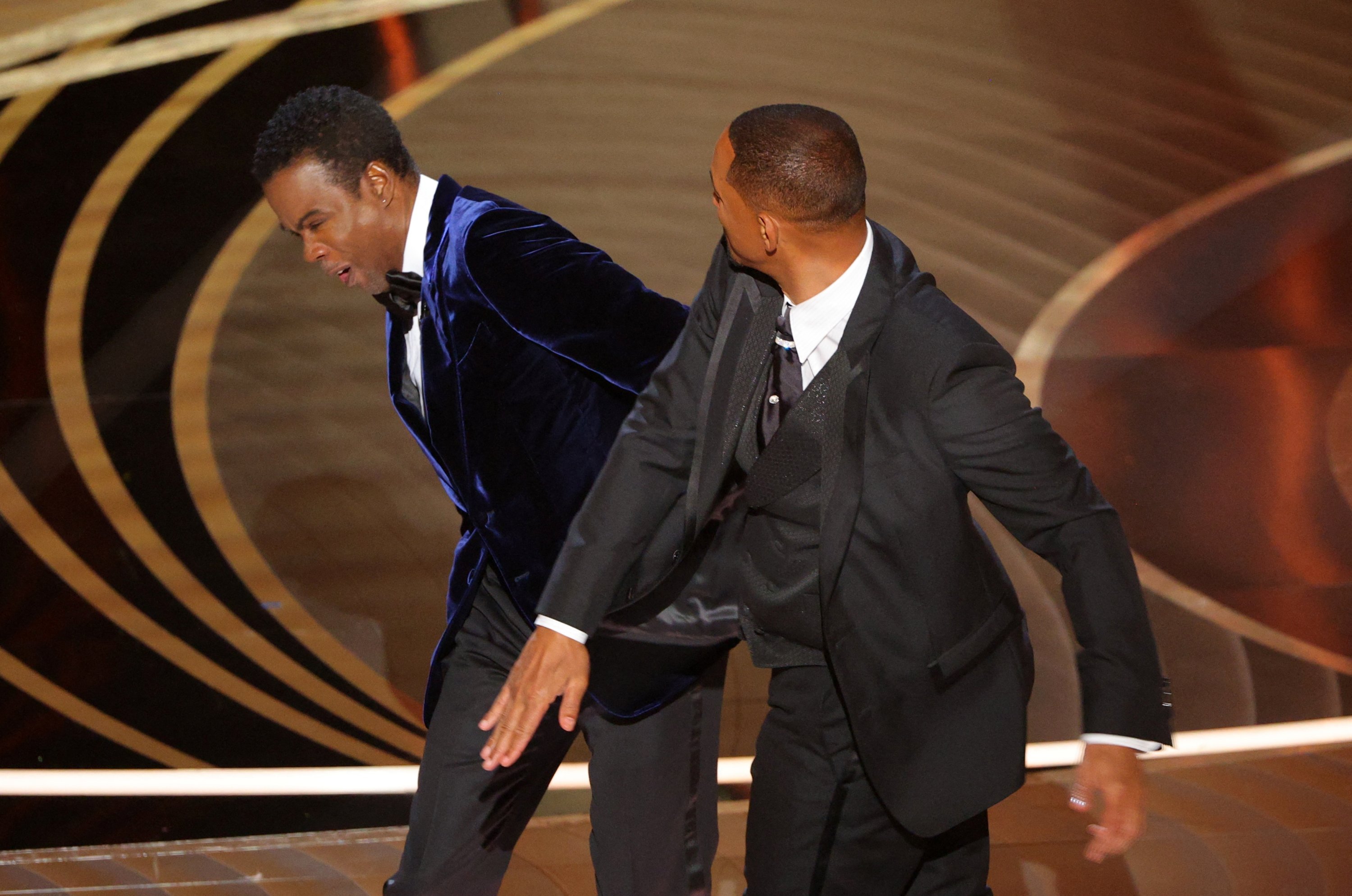 Will Smith (kanan) memukul Chris Rock saat Rock berbicara di atas panggung selama Academy Awards ke-94 di Hollywood, Los Angeles, California, AS, 27 Maret 2022. (Foto Reuters)