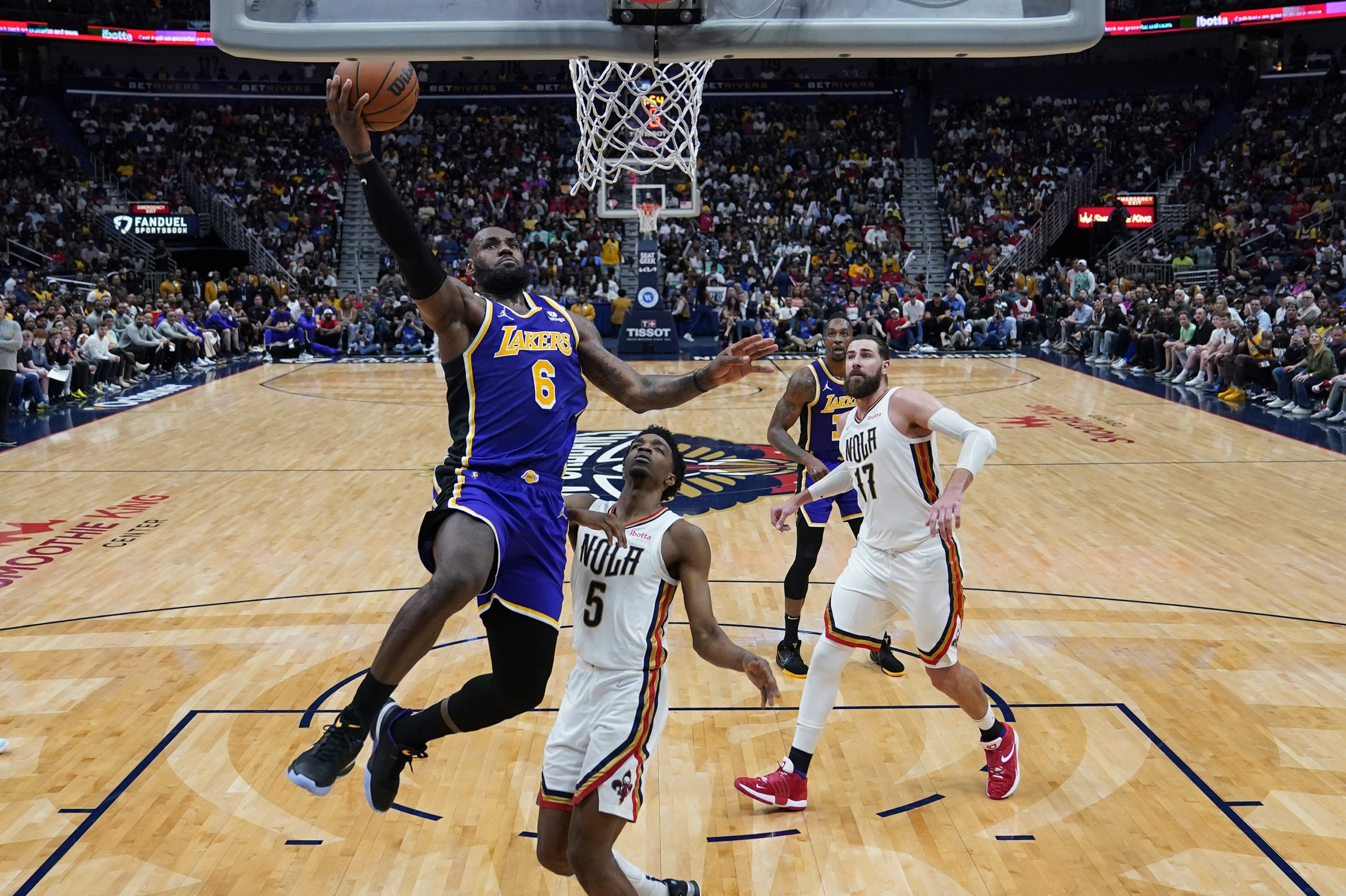 LeBron James (kiri) Lakers masuk ke keranjang melawan penyerang Pelicans Herbert Jones (kanan) dalam pertandingan NBA, New Orleans, AS, 27 Maret 2022. (AP Photo)