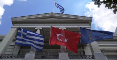 The Greek (L), Turkish (C) and European Union flags wave on the Greek Foreign Ministry house before a meeting of Foreign Minister  Mevlüt Çavuşoğlu and his Greek counterpart Nikos Dendias in Athens, Greece, May 31, 2021. (AP File Photo)