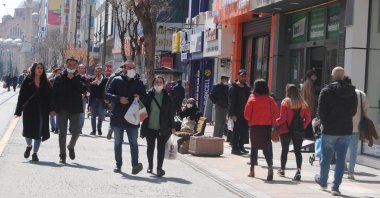 People wearing protective masks walk on a street in Eskişehir, central Turkey, March 28, 2022. (DHA PHOTO)