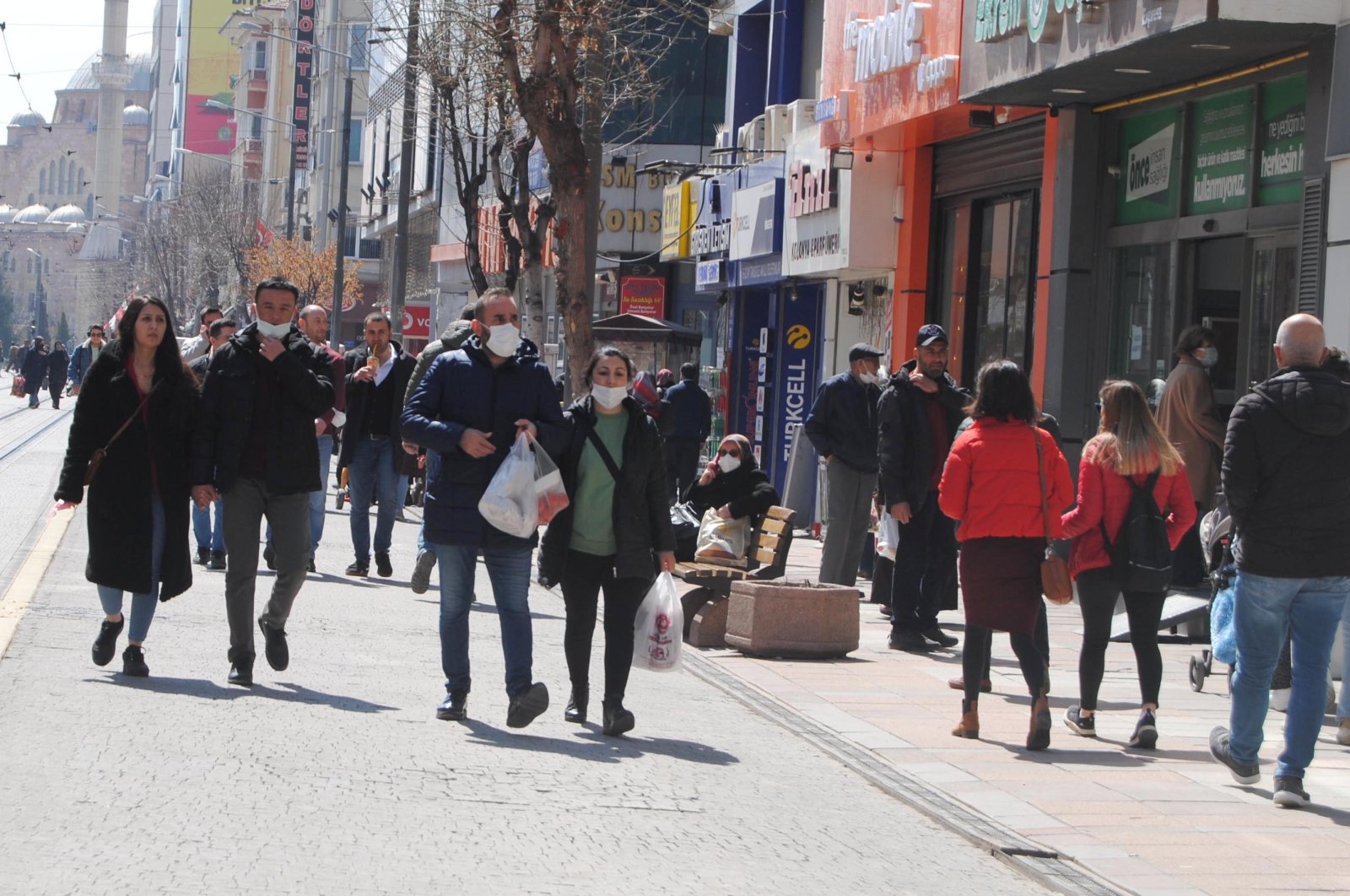 People wearing protective masks walk on a street in Eskişehir, central Turkey, March 28, 2022. (DHA PHOTO)
