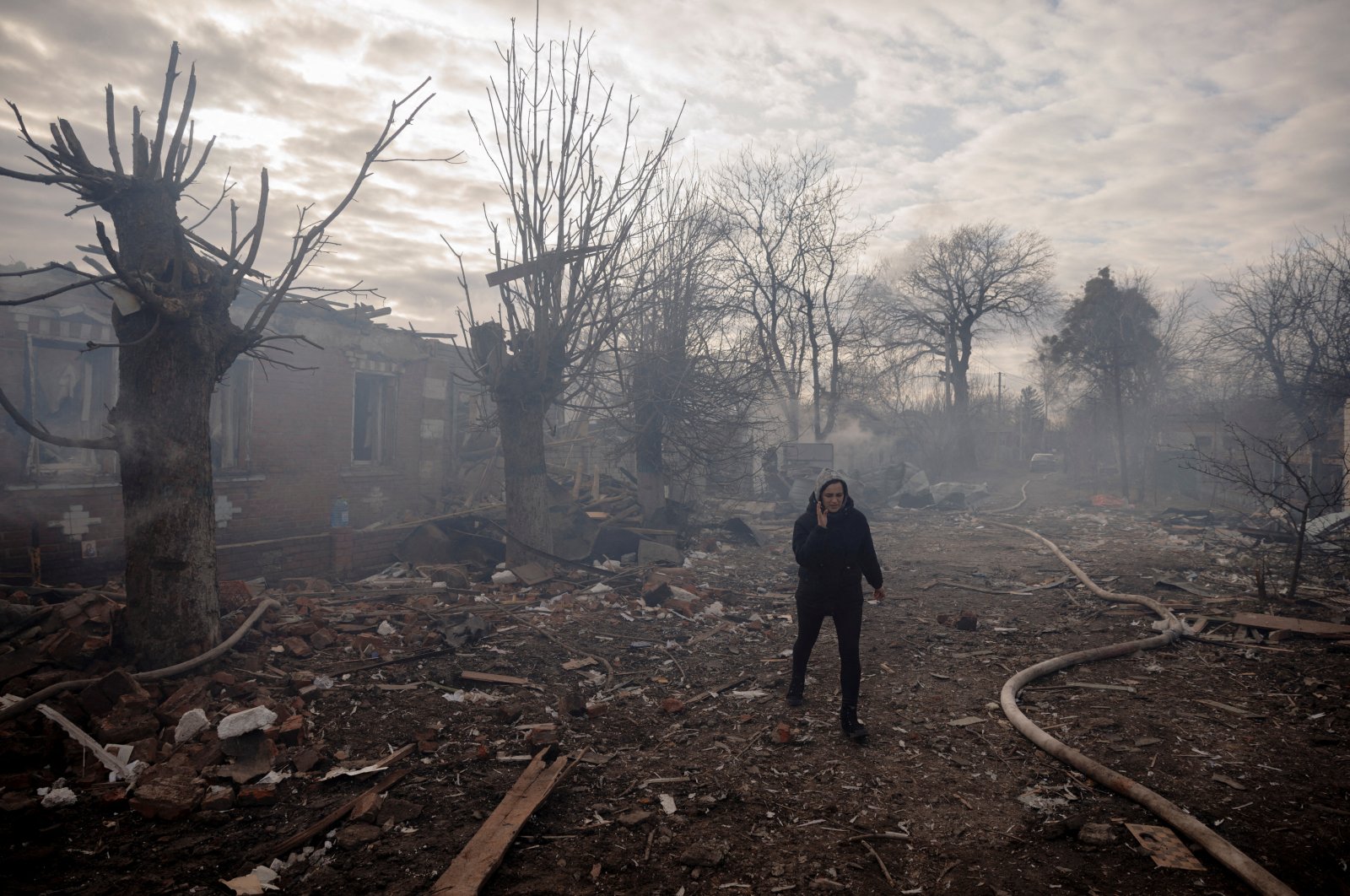 A woman walks between residential houses destroyed by Russian shelling in a settlement outside Kharkiv, Ukraine, March 28, 2022. (Reuters Photo)
