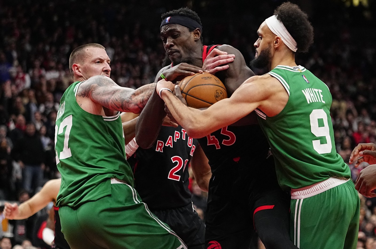 Raptors&#039; Pascal Siakam (C) grabs a rebound from Celtics&#039; Daniel Theis (L) and guard Derrick White during an NBA game, Toronto, Canada, March 28, 2022. (Reuters Photo)