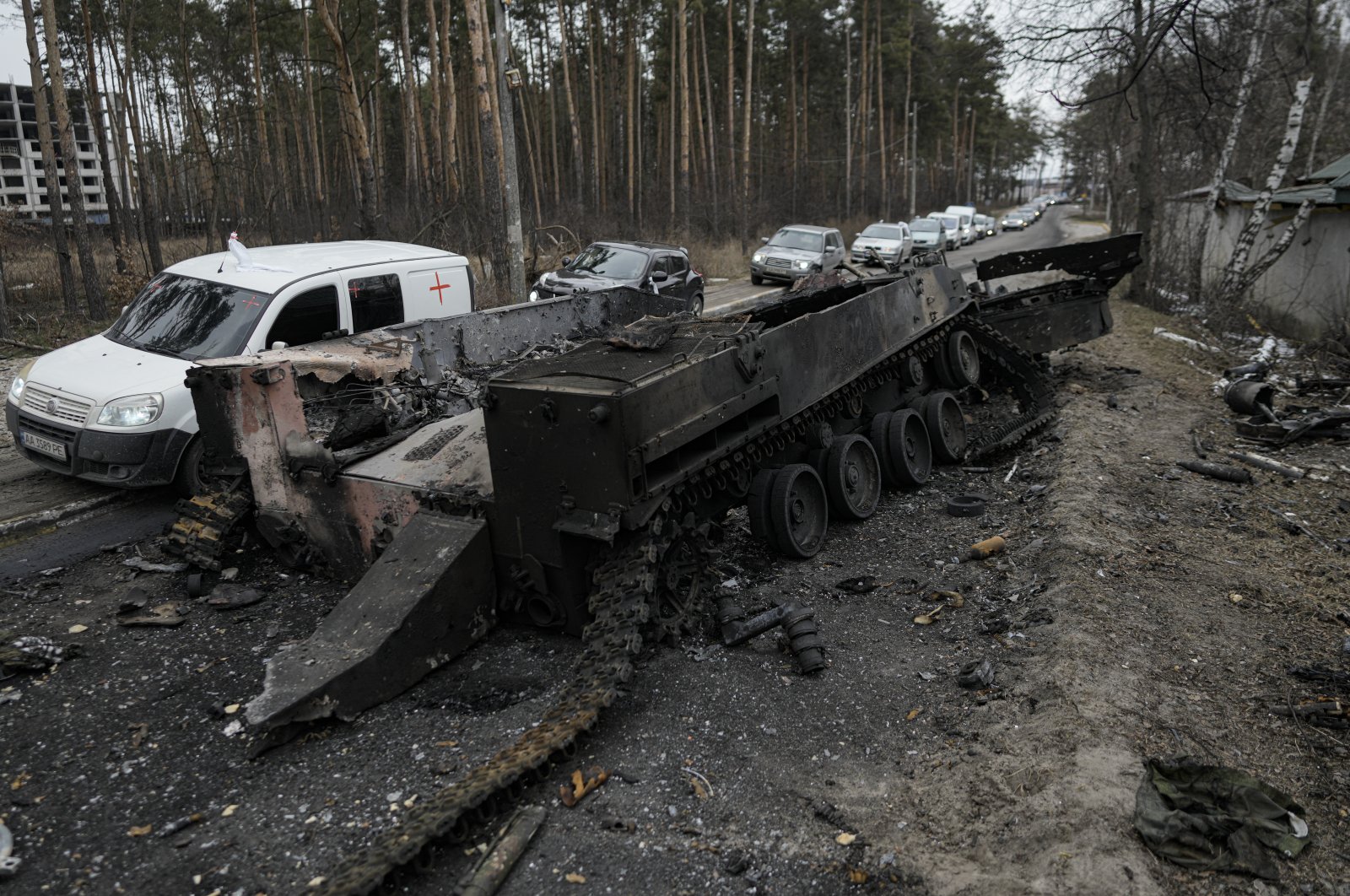 Cars drive past a destroyed Russian tank as a convoy of vehicles evacuating civilians leaves Irpin, on the outskirts of Kyiv, Ukraine, March 9, 2022. (AP Photo)