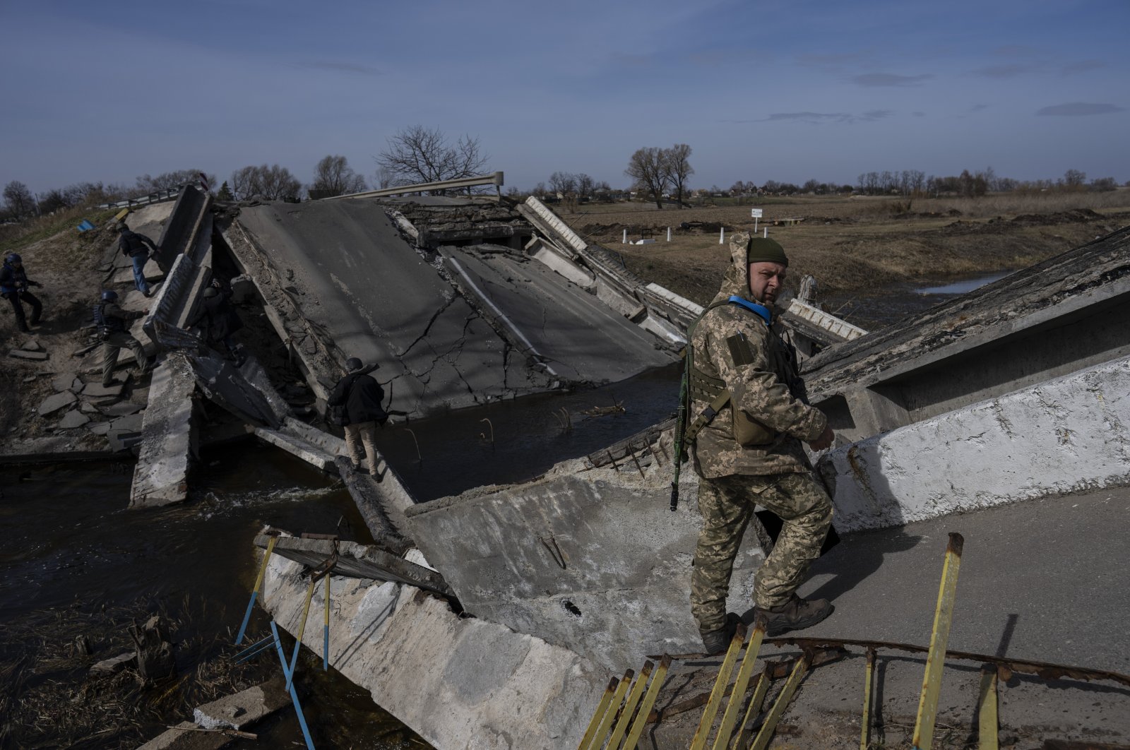 A soldier stands on a bridge destroyed by the Ukrainian army to prevent the passage of Russian tanks near Brovary, on the outskirts of Kyiv, Ukraine, March 28, 2022. (AP Photo)