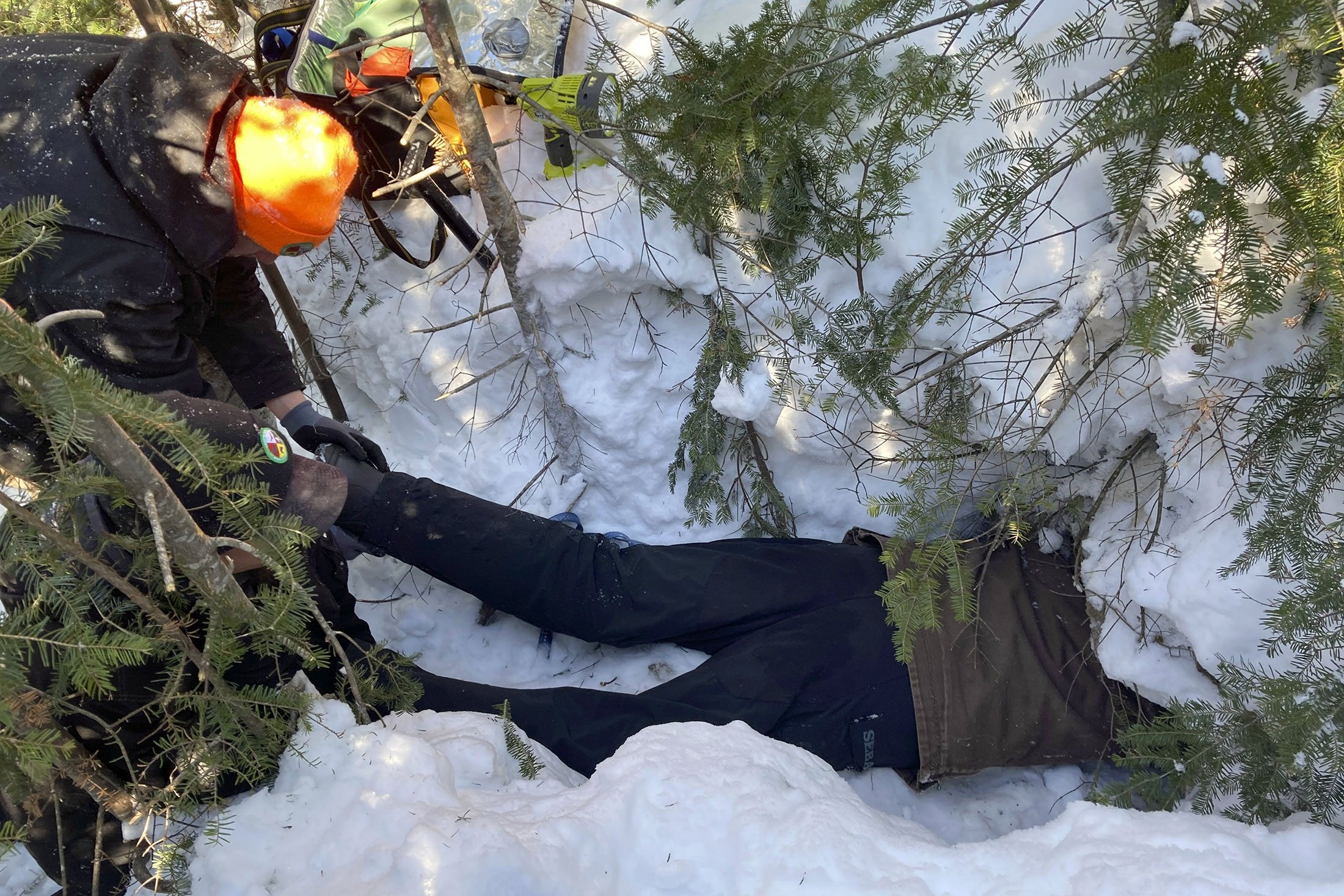 Todd Kautz, seorang peneliti pasca-doktoral dari Universitas Negeri New York, berbaring di perutnya untuk mengambil sampel biologis dari beruang yang sedang berhibernasi di sarangnya saat seorang rekan memegang kakinya, di Grand Portage, Minnesota, AS, 2 Maret 2022 (Foto AP)
