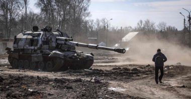 A resident walks near a damaged Russian tank in the northeastern city of Trostianets, Ukraine, March 29, 2022. (AFP Photo)