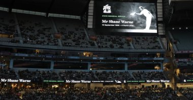 A photo of Shane Warne is projected onto screens during a memorial service for Warne, Melbourne, Australia, March 30, 2022. (AP Photo)
