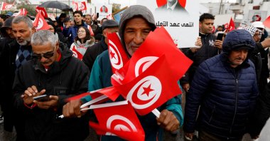 A man holds Tunisian national flags during a protest against Tunisian President Kais Saied's seizure of governing powers, in Tunis, Tunisia March 20, 2022. (Reuters Photo)
