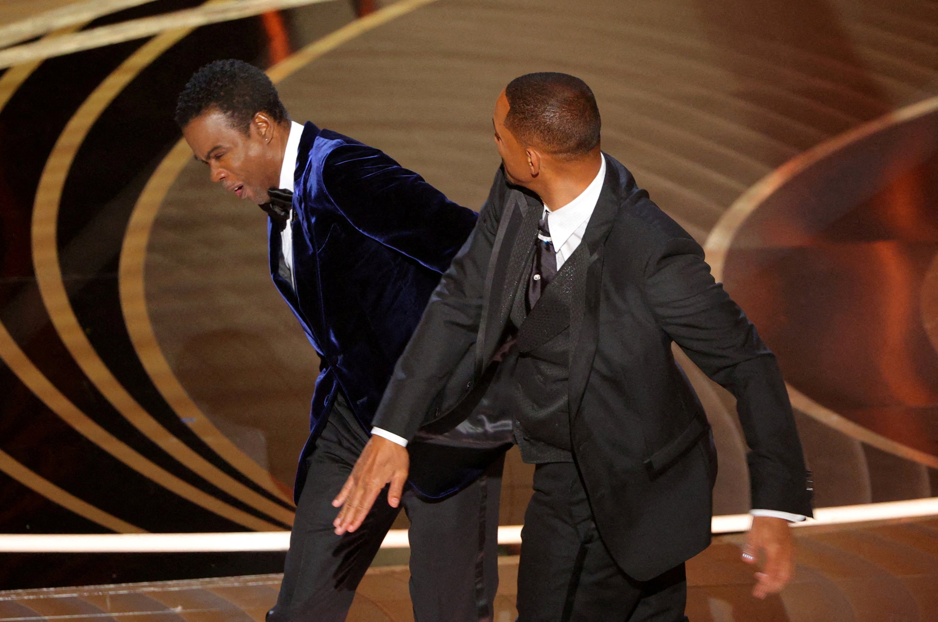 Will Smith (kanan) memukul Chris Rock saat Rock berbicara di atas panggung selama Academy Awards ke-94 di Hollywood, Los Angeles, California, AS, 27 Maret 2022. (REUTERS)