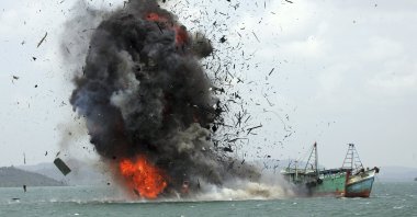 Debris flies into the air as foreign fishing boats are blown up by the Indonesian Navy off Batam Island, Indonesia, Feb. 22, 2016. (AP Photo)