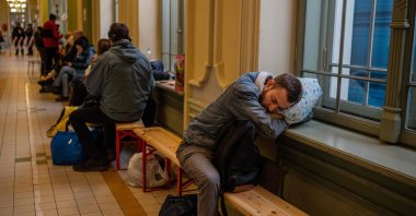 A refugee from Ukraine sleeps in the hall of the main railway station in Przemysl, southeastern Poland, near the Polish-Ukrainian border on March 31, 2022. (AFP Photo)