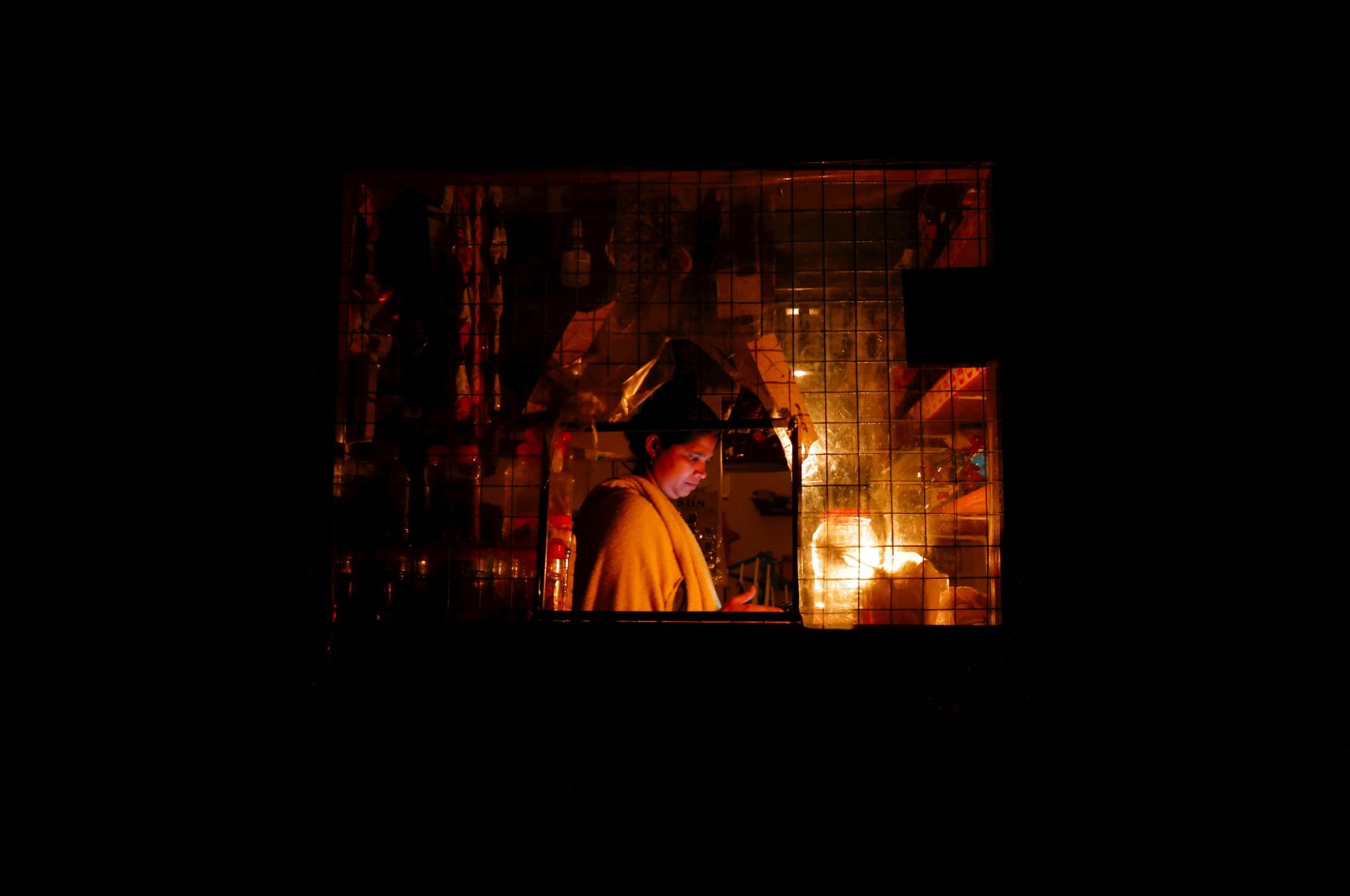 A woman works inside a shop attached to her house during the power cut in Colombo, Sri Lanka, March 30, 2022. (Reuters Photo)