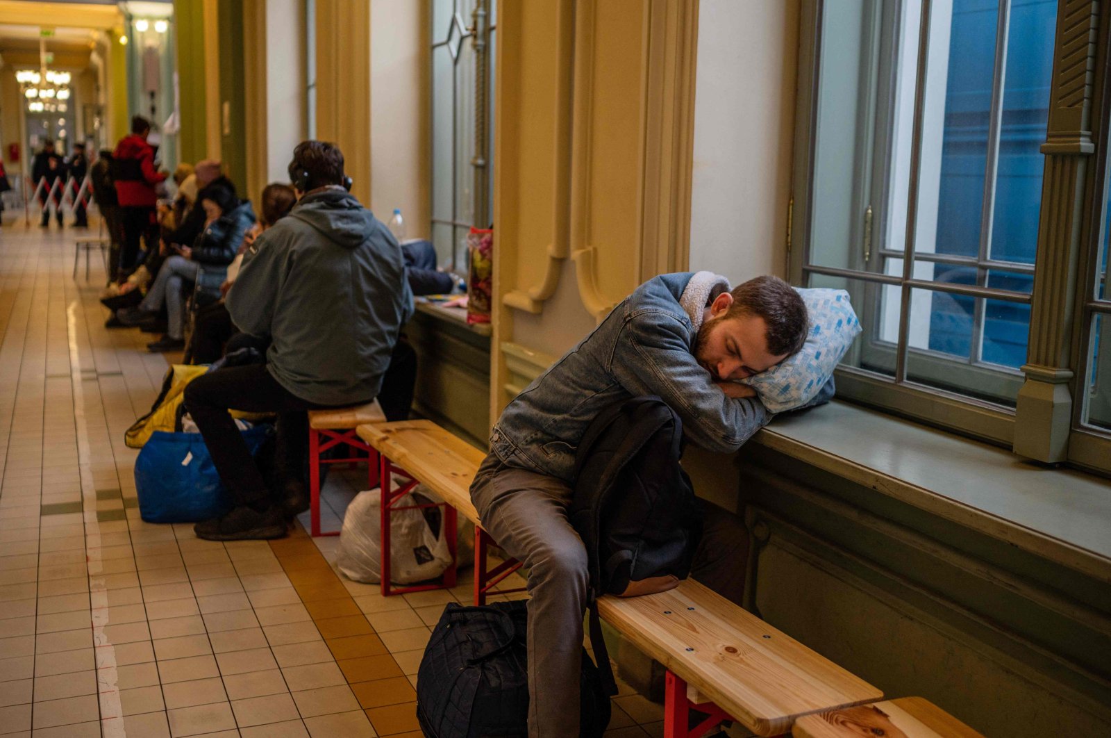 A refugee from Ukraine sleeps in the hall of the main railway station in Przemysl, southeastern Poland, near the Polish-Ukrainian border on March 31, 2022. (AFP Photo)