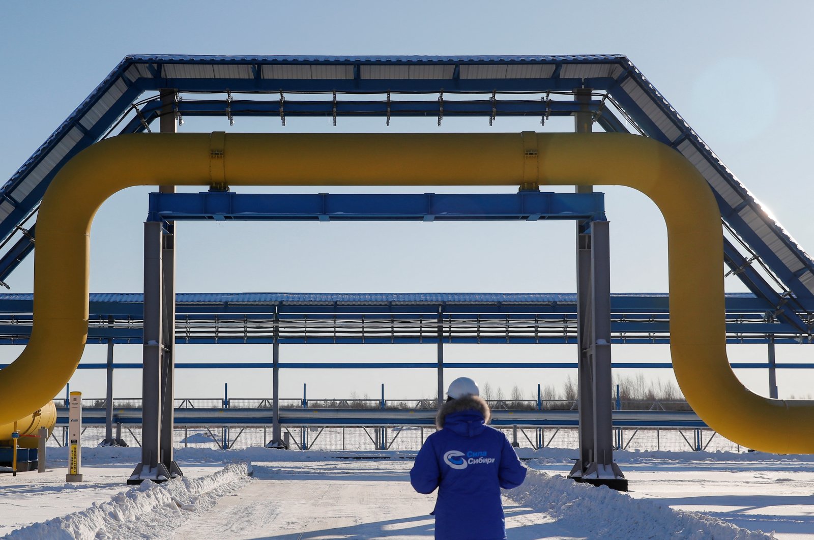 An employee in a branded jacket walks past a part of Gazprom&#039;s Power Of Siberia gas pipeline at the Atamanskaya compressor station outside the far eastern town of Svobodny, in the Amur region, Russia, Nov. 29, 2019. (Reuters Photo)