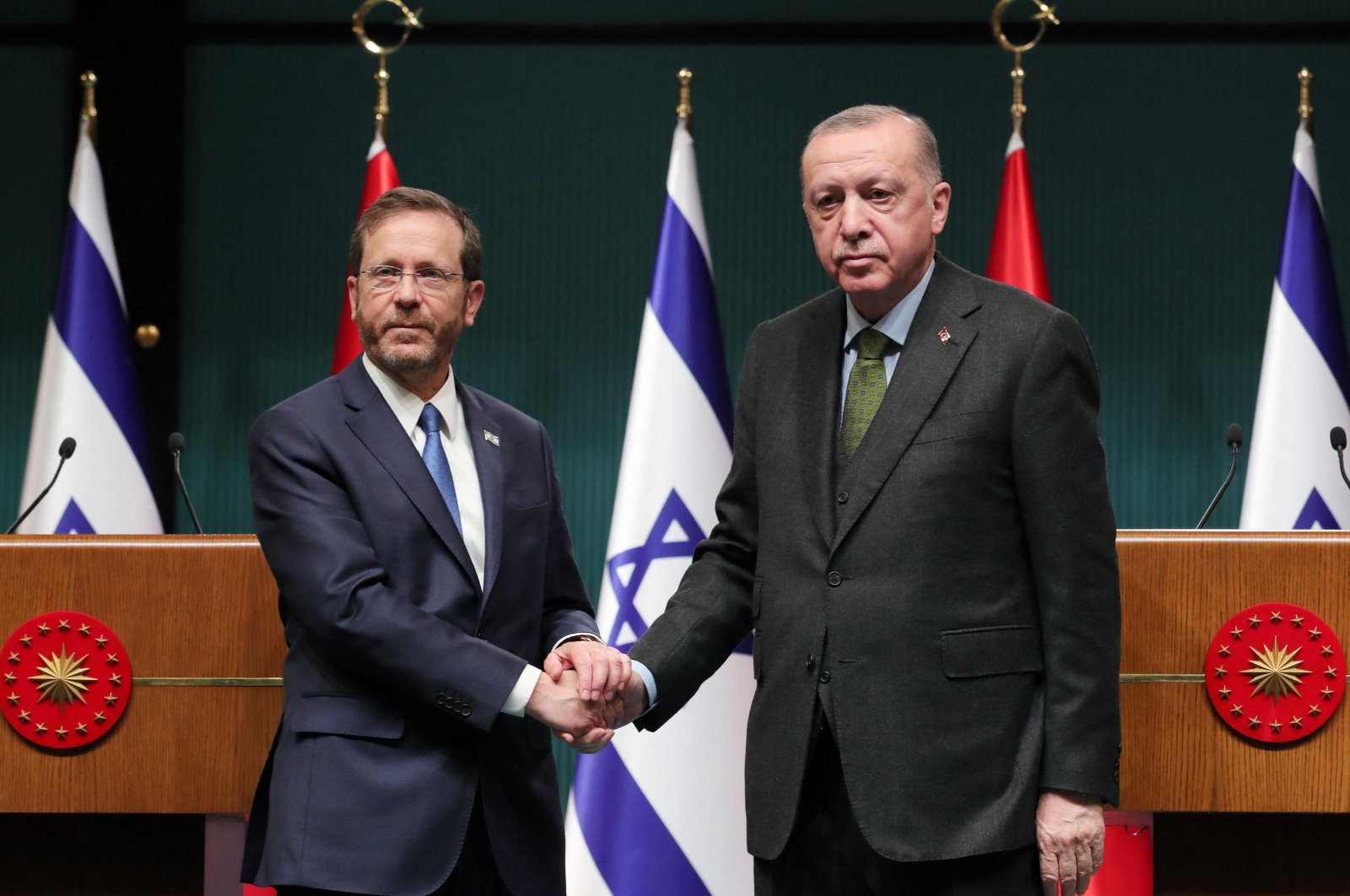 This handout picture released on March 9, 2022 by the Turkish Presidential Press Service shows Israeli President Isaac Herzog (L) and his Turkish counterpart Recep Tayyip Erdoğan shaking hands after a joint press conference in Ankara. (AFP Photo)
