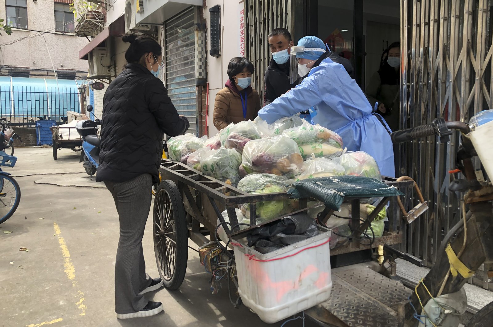 Neighborhood committee members prepare to deliver vegetables door to door in the locked down Jingan district of western Shanghai, China, April 1, 2022. (AP Photo)