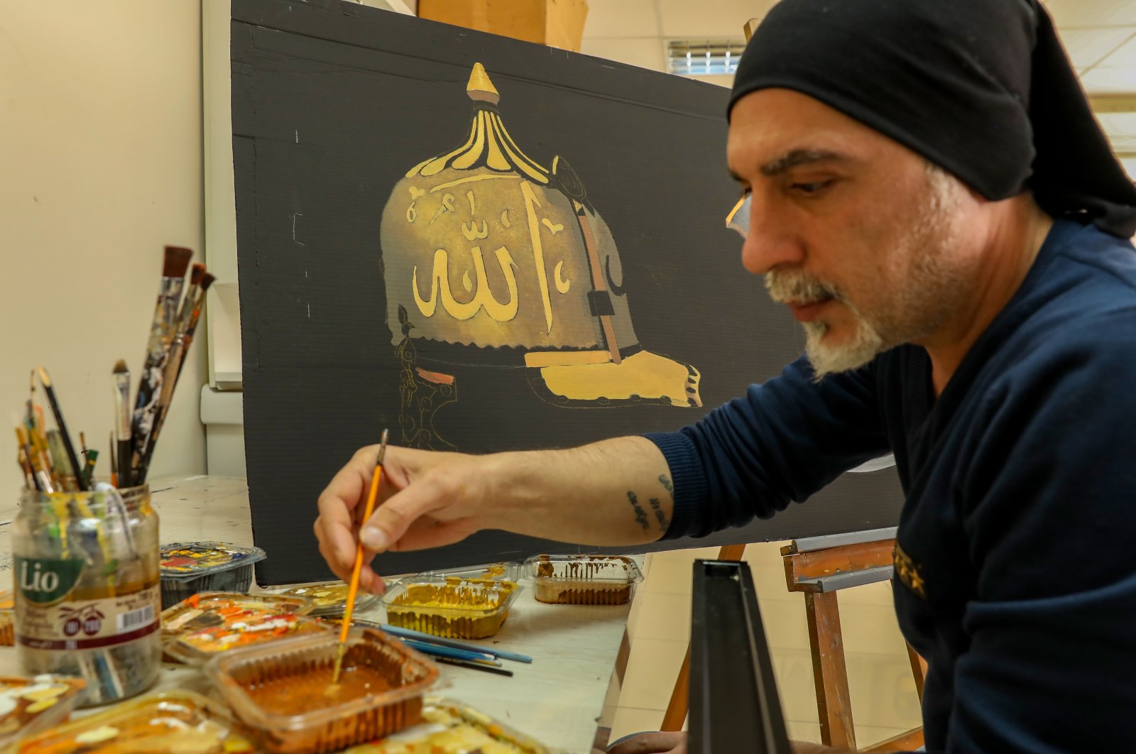 An artist works on a painting of an Ottoman sultan&#039;s helmet at a workshop of the Diyarbakır Advanced Technical School, southeastern Turkey, March 29, 2022. (AA Photo)