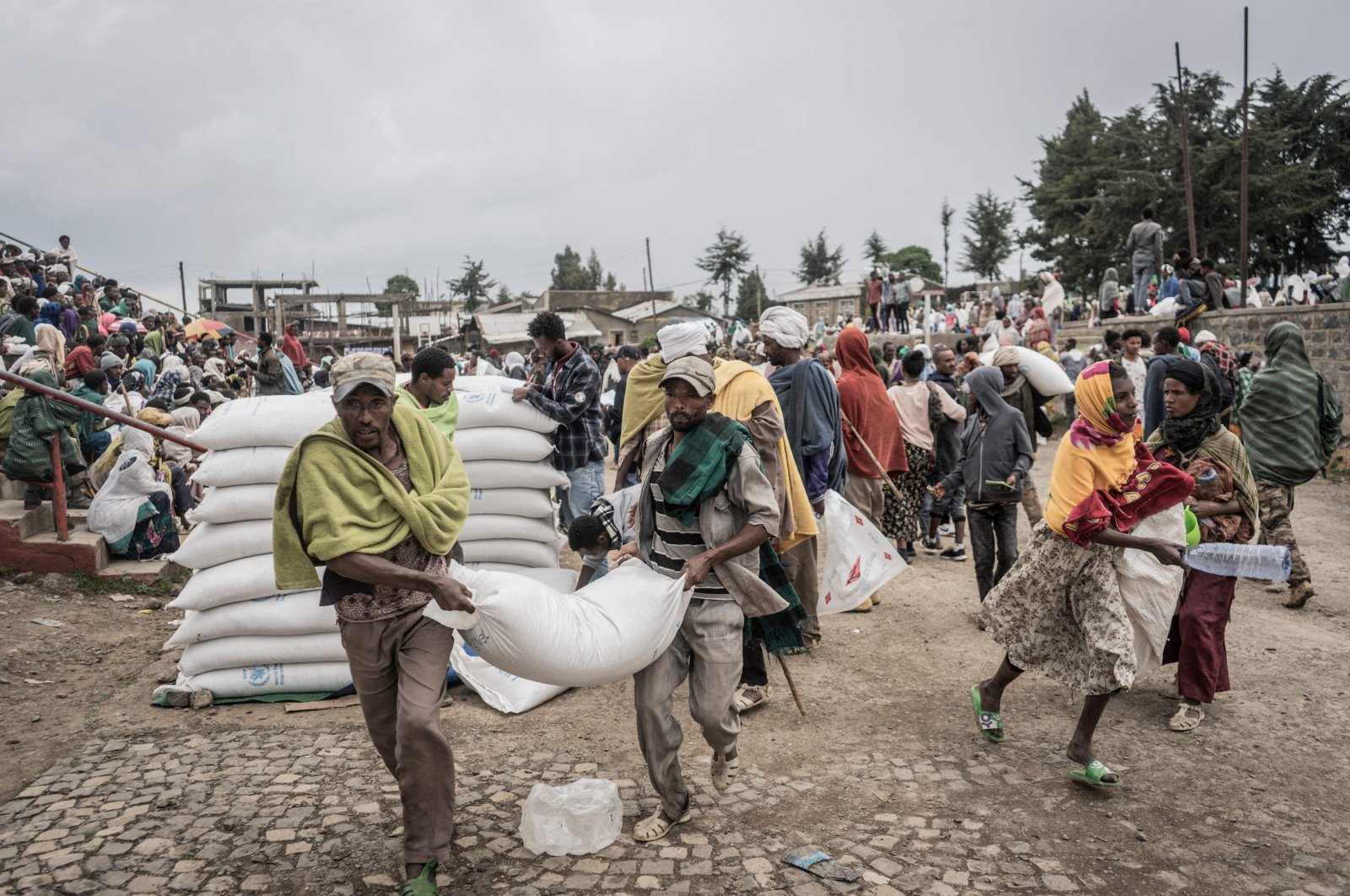 In this file photo taken on Sept. 15, 2021, Men carry a sack of wheat during a food distribution by the World Food Programme (WFP) for internally displaced people (IDP) in Debark, 90 kilometers from the city of Gondar, Ethiopia. (AFP Photo)