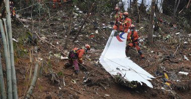 In this photo released by Xinhua News Agency, search and rescue workers search through debris at the China Eastern flight crash site in Tengxian County in southern China's Guangxi Zhuang Autonomous Region, March 24, 2022. (Xinhua via AP File)