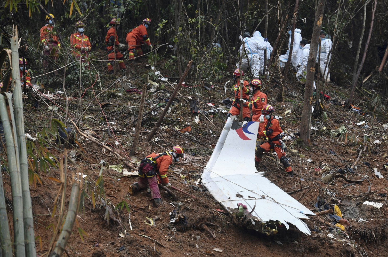 In this photo released by Xinhua News Agency, search and rescue workers search through debris at the China Eastern flight crash site in Tengxian County in southern China&#039;s Guangxi Zhuang Autonomous Region, March 24, 2022. (Xinhua via AP File)