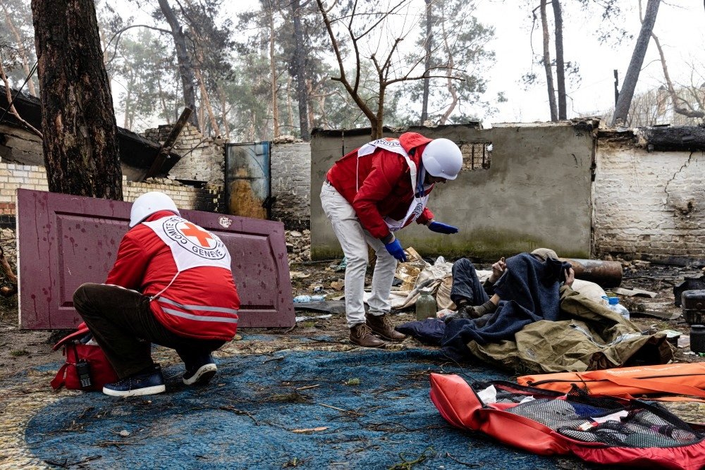 Red Cross staff help a local resident as the humanitarian organization delivers food and first aid to residents that have been affected by fighting during Russia&#039;s invasion of Ukraine, in Irpin, April 1, 2022. (Reuters via International Committee of the Red Cross)