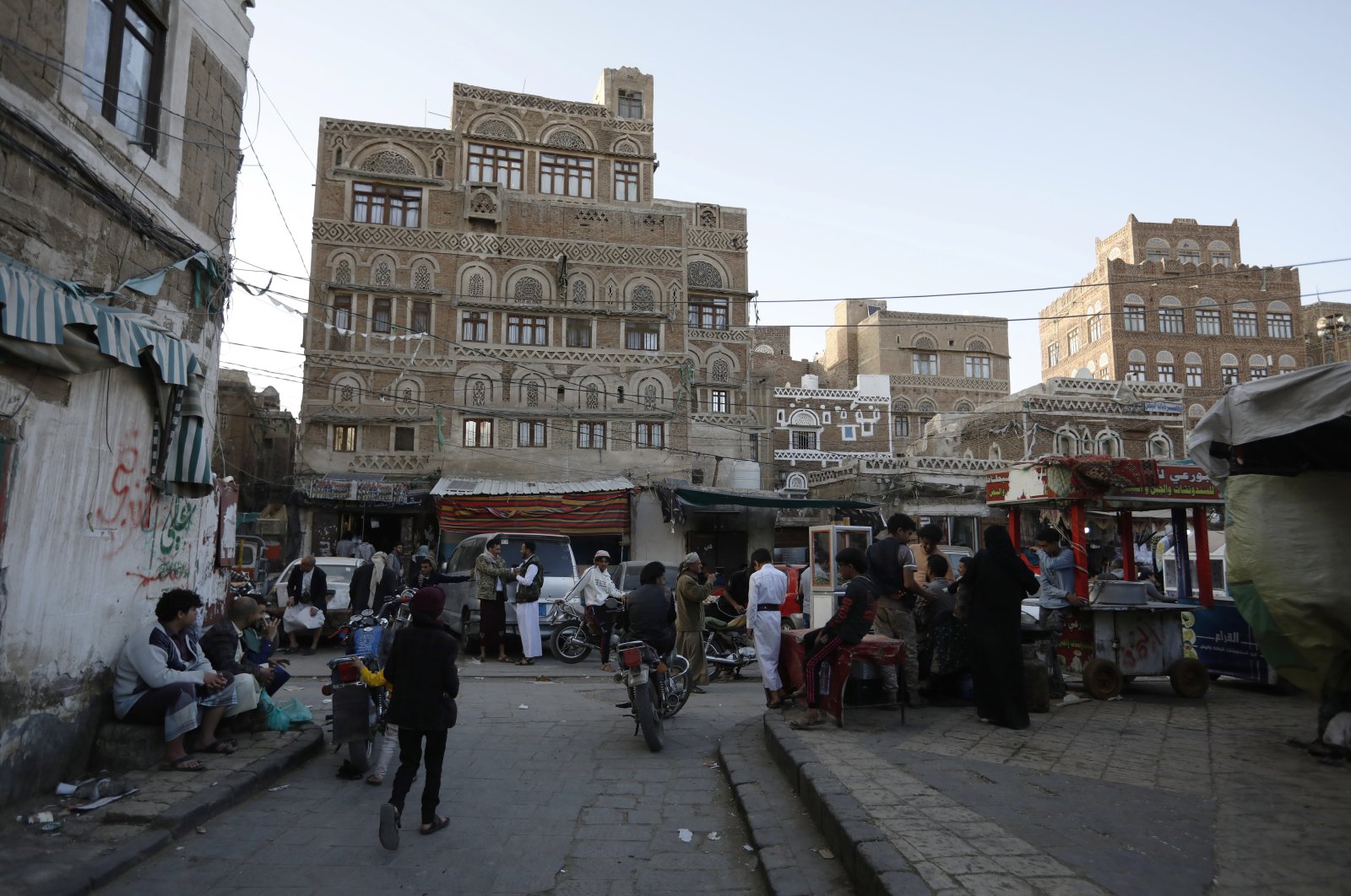 Yemenis walk past buildings, a day after the warring parties agreed to a two-month truce, in the old city of Sanaa, Yemen, April 2, 2022. (EPA)