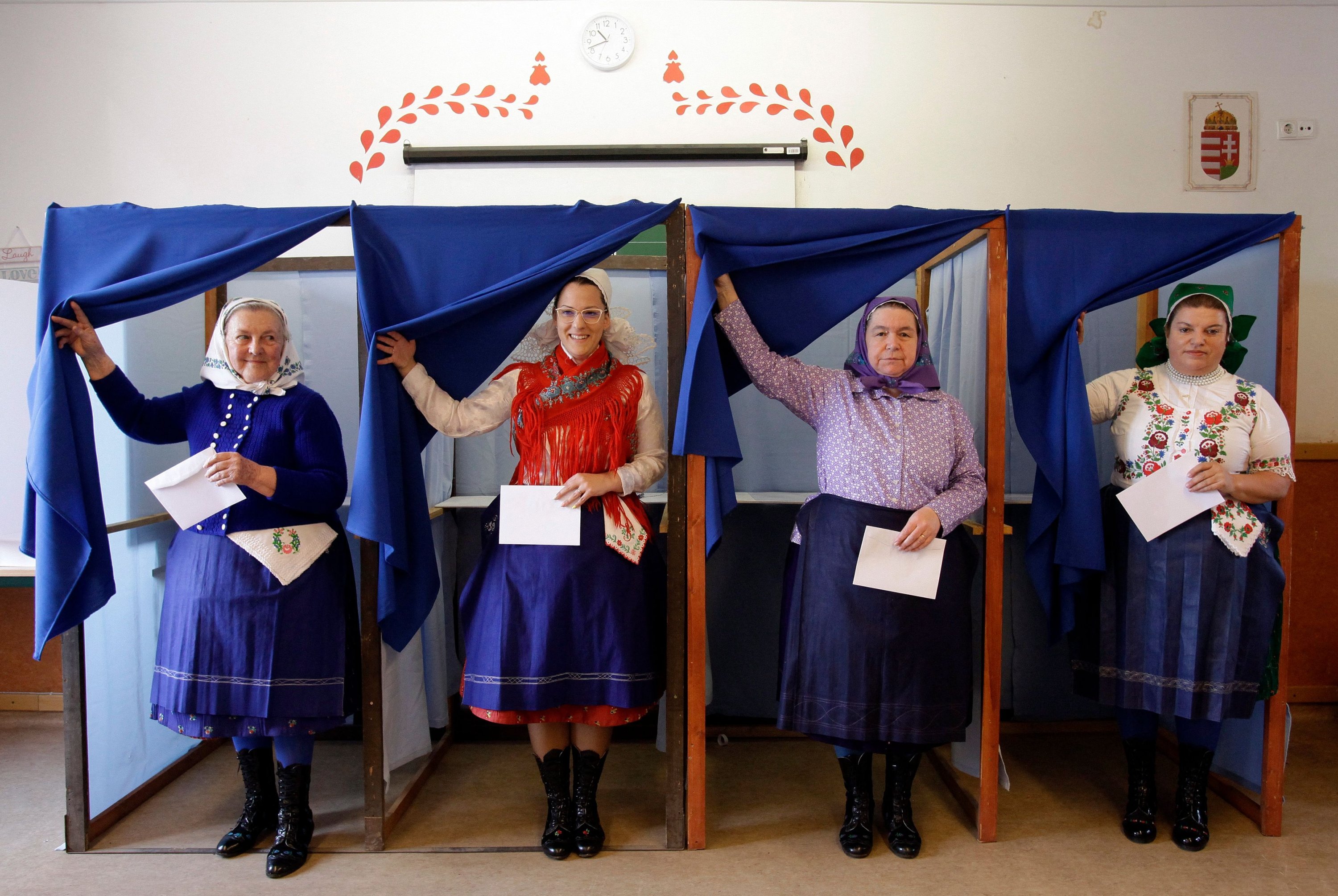 Women in traditional Hungarian dresses leave polling booths and prepare to cast their ballots at a polling station in a school in Veresegyhaz, 30 kilometers (18.64 miles) east of Budapest, Hungary, April 3, 2022. (AFP Photo)