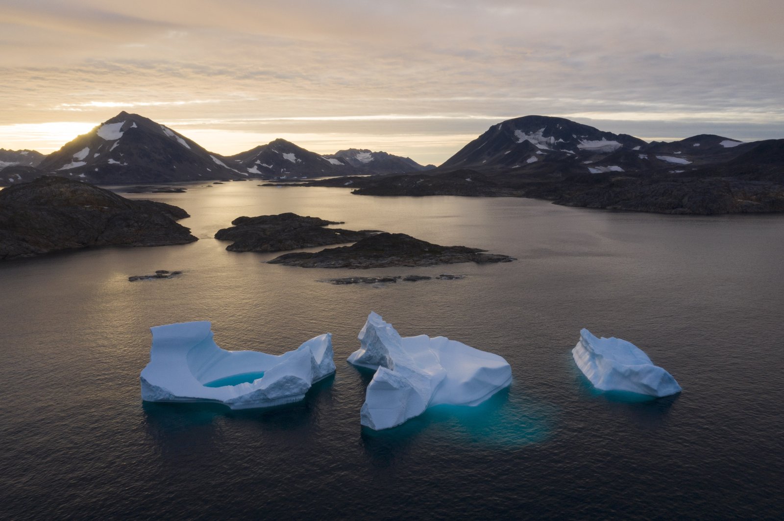 Large icebergs float away as the sun rises near Kulusuk, Greenland, Aug. 16, 2019. (AP File Photo)