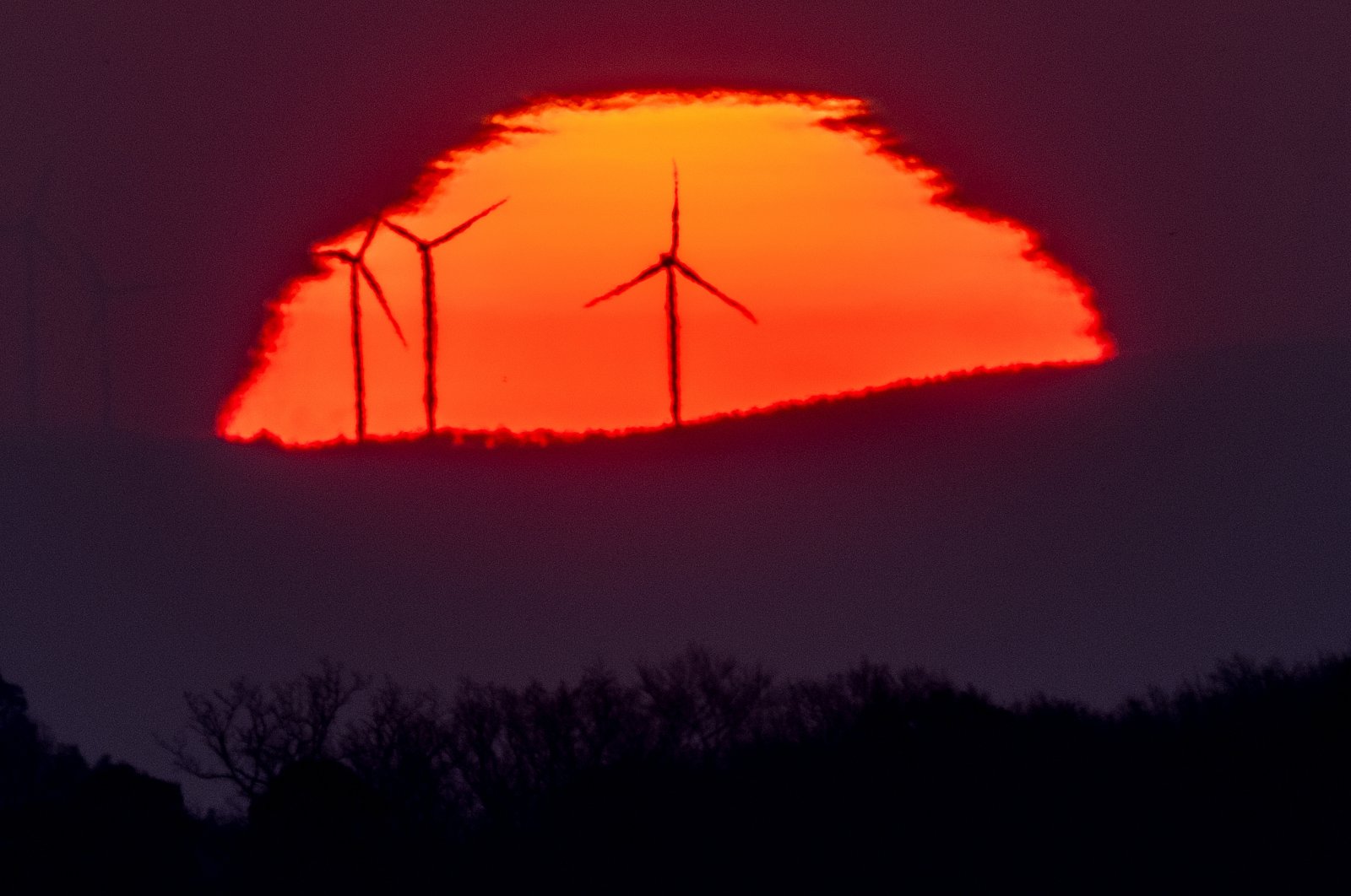 Wind turbines stand in front of the rising sun in Frankfurt, Germany, March 11, 2022. (AP Photo)