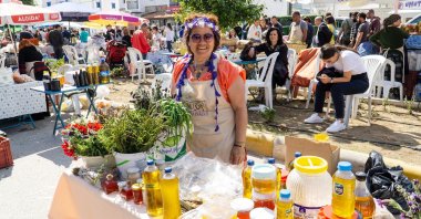 A young woman sells vegetables, fruits and olive oil at a festival, in Bodrum, Turkey, March 15, 2020. (Shutterstock Photo)