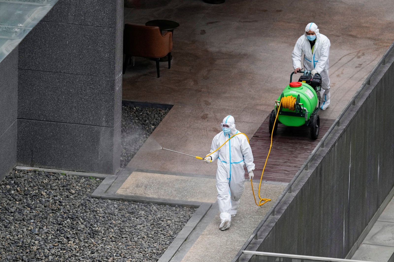 Workers in protective suits spray disinfectant at a community, during the lockdown to curb the spread of the coronavirus in Shanghai, China, April 5, 2022. (Reuters Photo)