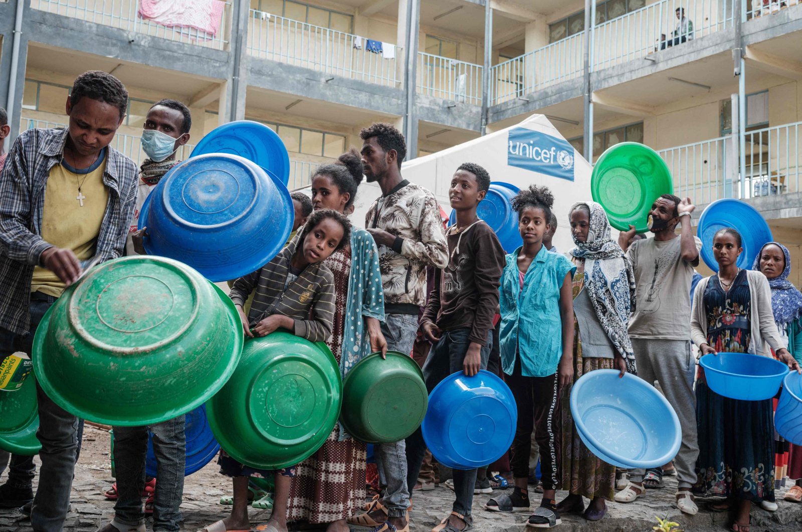 People who fled the violence wait to receive injeras, Ethiopia&#039;s staple food of sour fermented flatbread, as their only meal of the day at May Weyni secondary school in Ethiopia&#039;s embattled Tigray region, June 19, 2021. (AFP Photo)