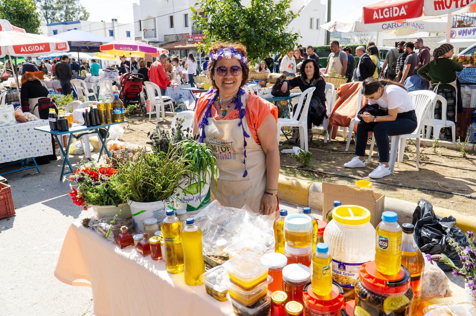 A young woman sells vegetables, fruits and olive oil at a festival, in Bodrum, Turkey, March 15, 2020. (Shutterstock Photo)