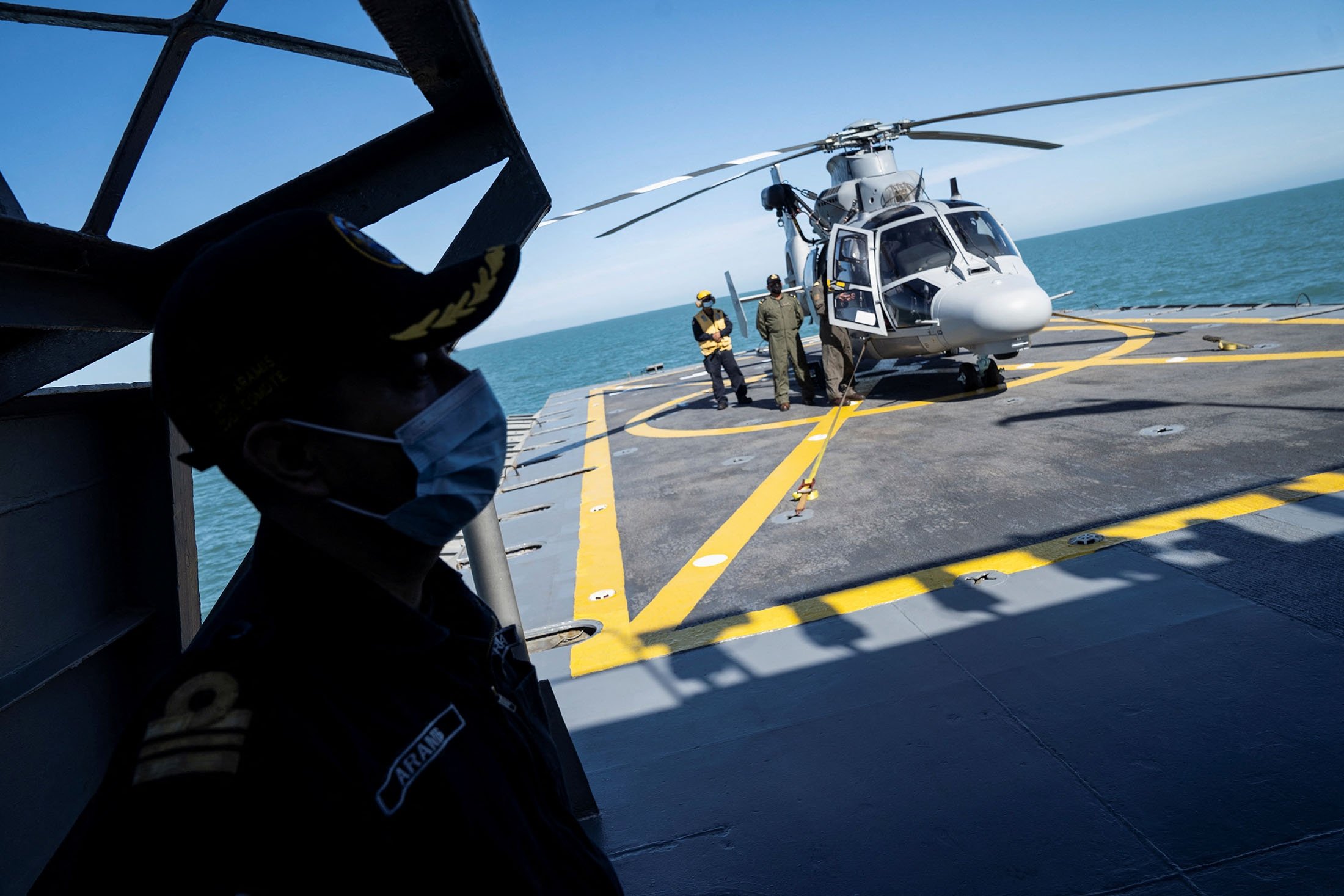 Des membres de la marine mexicaine se tiennent à côté d'un hélicoptère de la marine à bord du navire ARM Sonora lors d'une tournée de presse en Basse-Californie, au nord-ouest du Mexique, le 31 mars 2022. (Photo Reuters)