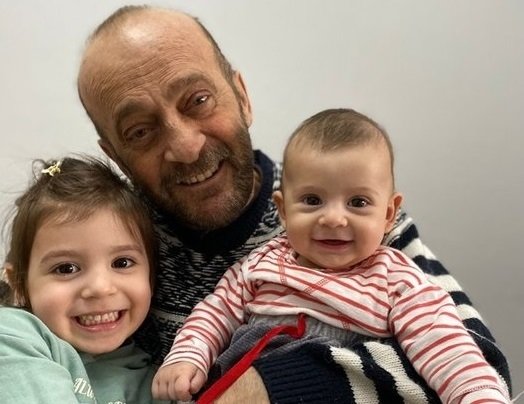 Muzaffer Kayasan who recovered from COVID-19 after 16 months hugs his grandchildren, Istanbul, Turkey, April 6, 2022. (Sabah Photo)