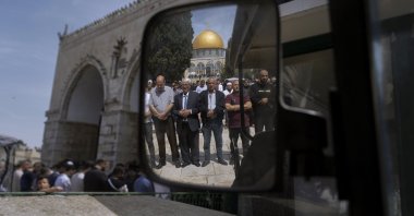 Muslim men are reflected in a mirror as they offer Friday prayers next to the Dome of the Rock Mosque in the Al-Aqsa Mosque complex in occupied East Jerusalem, Palestine, April 1, 2022. (AP Photo)