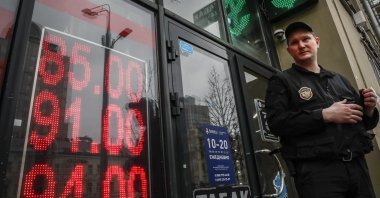 A security guard stands in front of an exchange office with a screen displaying the exchange rates of the euro and U.S. dollar to Russian rubles in Moscow, Russia, March 31, 2022. (EPA Photo)