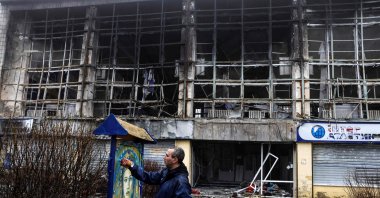 French street artist Christian Guemy, known as C215, paints one of his works next to a metro station and food market that were badly damaged by a Russian strike in Kyiv, Ukraine, April 1, 2022. (AFP Photo)